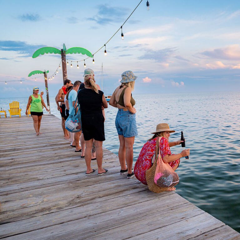 Guests at Palapa Bar & Grill gather on the dock to look at stingrays swimming right next to the restaurant